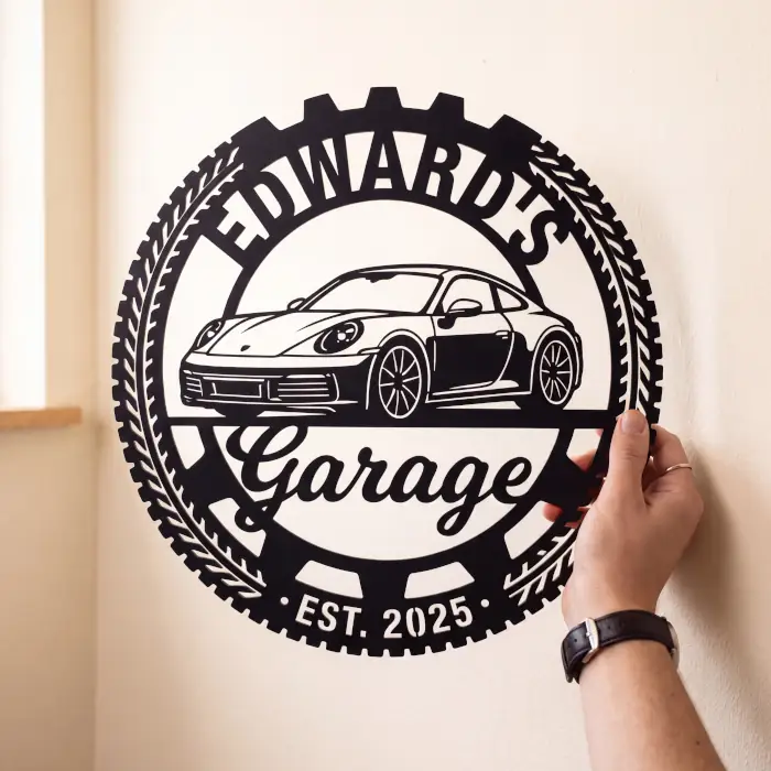 A person holding a finished, custom-cut black garage sign featuring a sports car. This demonstrates the flawless physical results achievable using our machine-ready vector cut files optimized for laser cutting and engraving.